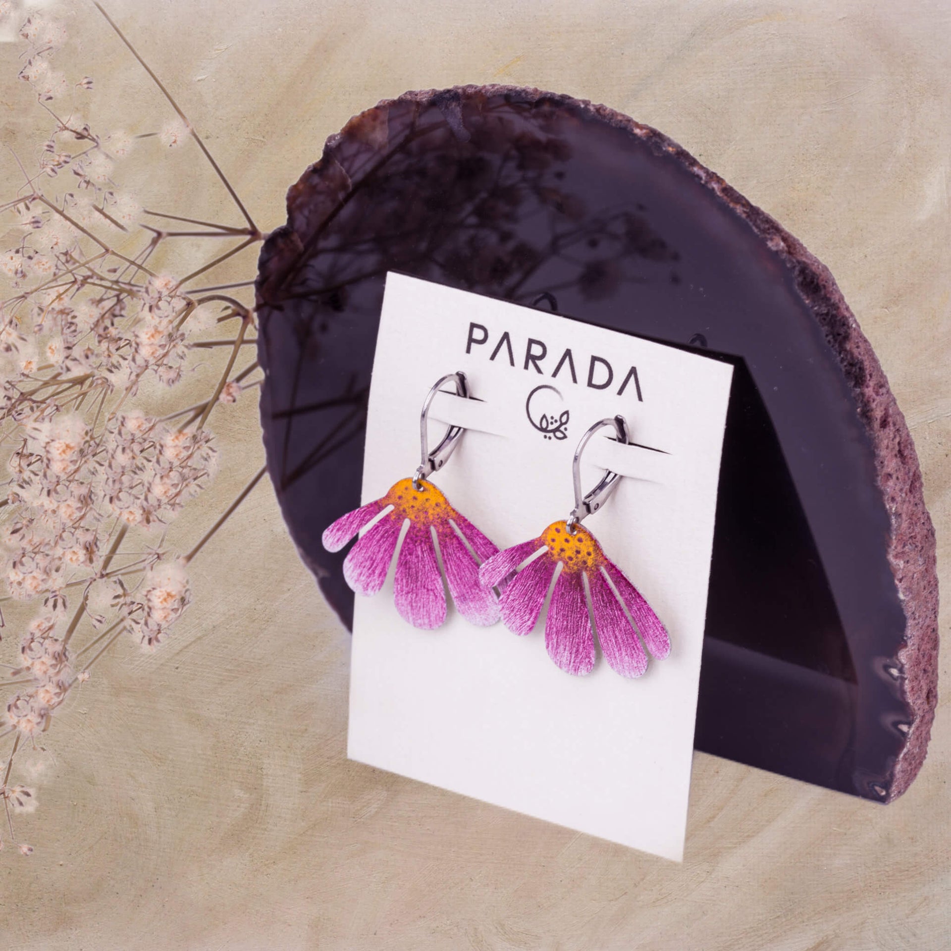 a stylized photo of handmade echinacea earrings displayed on a branded card PARADA